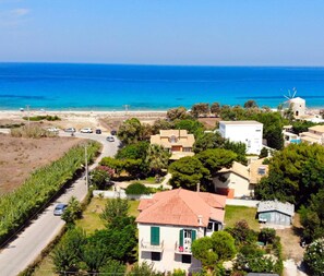 Une zone résidentielle côtière comprenant des maisons, une route et une plage.