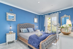 A bedroom with a bed, nightstands, a dresser, and a mirror.
