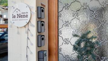 Une porte ornée d’un motif métallique décoratif et d’une enseigne indiquant « le Nene Dolomiti Guesthouse ».