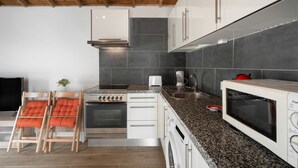 Eine moderne Küche mit Einbauofen, Mikrowelle und Spüle aus Edelstahl.