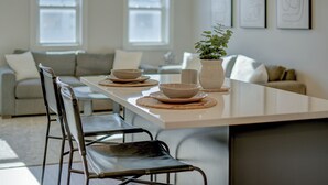 Una cocina moderna con una isla central, una mesa de comedor y un sofá.