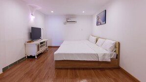 A bedroom with a bed, a TV on a stand, and an air conditioning unit on the wall. - Venus Hotel & Massage - Bui Vien Walking (Ho Chi Minh City)