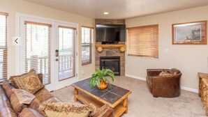 A living room with a fireplace, a sofa, a coffee table, and a television. - 3-bedroom condo in fabulous Eden, skiing, biking, hiking, and water sports (Eden)