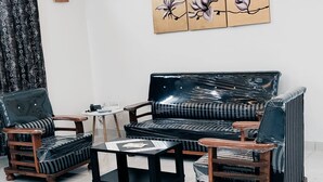 A living room with a sofa, two armchairs, and a coffee table. - Zenith Paradise-Luxurious 3BR Apartment (Hyderabad)
