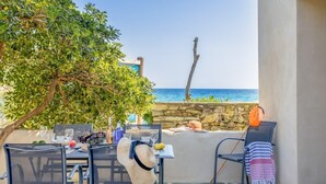 Un área de comedor al aire libre con una mesa dispuesta para dos, con vista al mar.