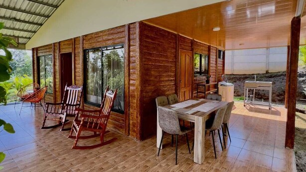 Un vaste espace intérieur doté d’un haut plafond, de murs en bois et d’une table à manger avec des chaises.