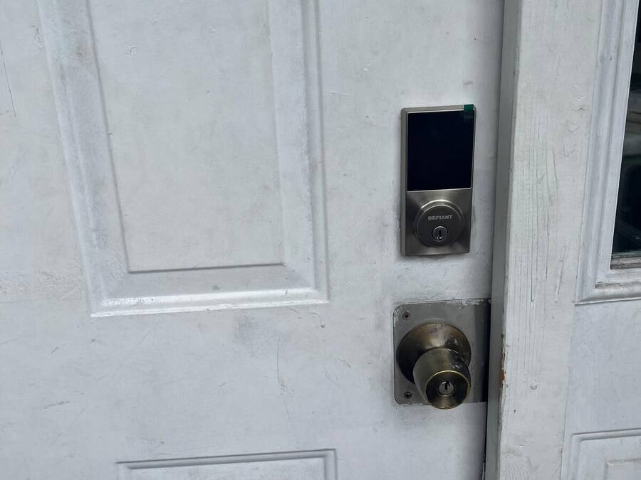 A white door with a keyhole and a small electronic lock.
