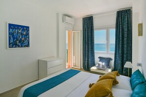 A hotel room with a bed, a painting on the wall, a window with curtains, and a view of the sea. - La Palomita. Spectacular ocean view (Fuengirola)
