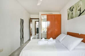 Une chambre d’hôtel avec un lit, une armoire en bois et un miroir.