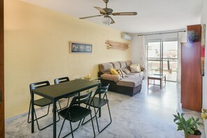 A dining area with a table and chairs, a sofa, and a ceiling fan. - Large pool, balcony & great views. Parking. (Benalmadena)