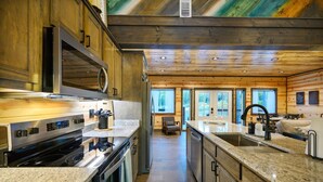 A modern kitchen with granite countertops, stainless steel appliances, and wooden cabinetry.
