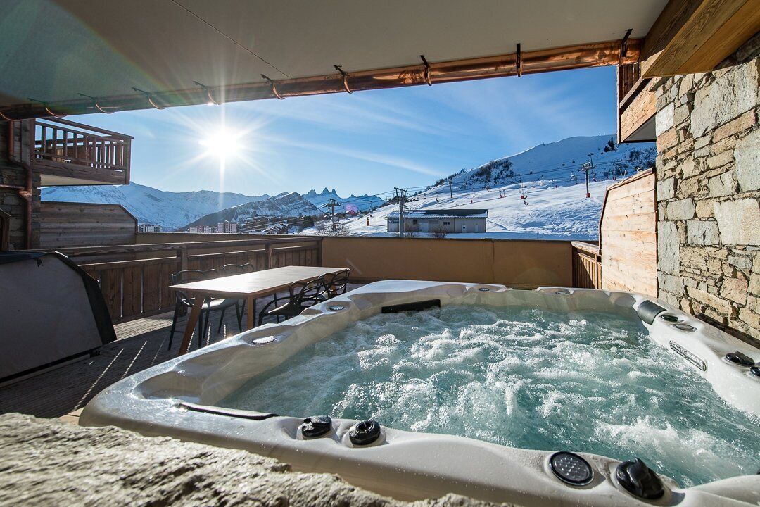 Ett bubbelbad med utsikt över ett snöklätt berglandskap.