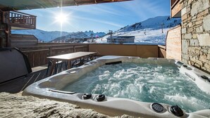 Ein Whirlpool mit Blick auf eine verschneite Berglandschaft.