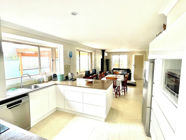 A modern kitchen with a central island, a dining area, and a built-in oven.