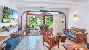 A spacious room with a large window, wooden furniture, and a view of the outdoors. - Beachfront paradise in Flamingo Marina - FM407 (Flamingo)