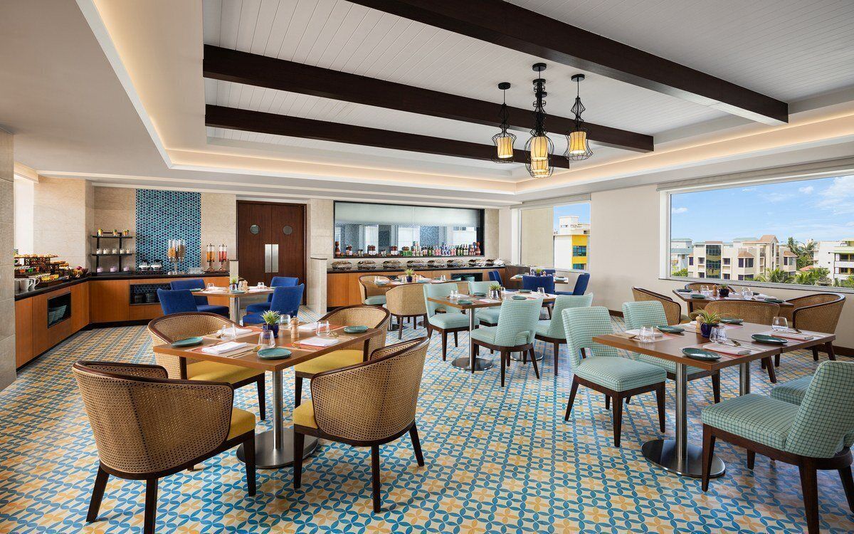 A spacious hotel lobby with a bar area, seating arrangements, and a patterned floor.