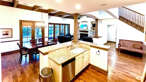 A spacious kitchen with a central island, wooden flooring, and a dining area with chairs and a table. -  Beautiful 4BR/4BA.Close to HHI/SAV/BEU, 5 minutes to Palmetto Bluff's entrance  (Bluffton)