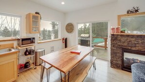 Une cuisine moderne avec une table en bois, un four à micro-ondes et une cheminée en pierre.