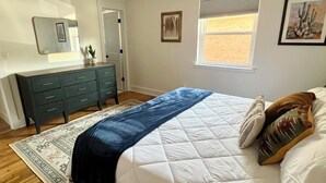 A bedroom with a bed, a dresser, a ceiling fan, a window, and a door. - Mid-West Mod-1 mile to OU-Central Norman-Sleeps 16 (Norman)