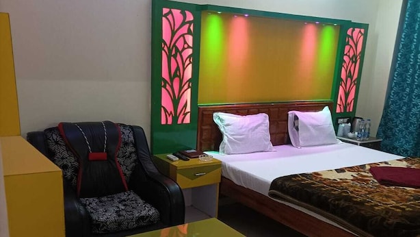 Una habitación de hotel con una cama, un sofá, una mesita y dos sillas.
