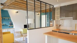 Una cocina moderna con encimera de madera, estufa integrada y una pared divisoria de vidrio.