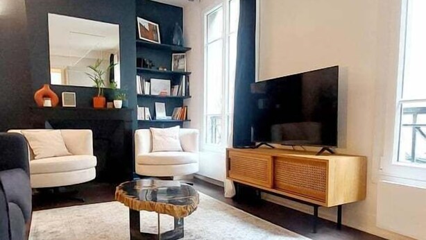Un salon moderne comprenant un canapé, un fauteuil, une table basse et un meuble pour la télévision.