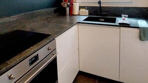 Une cuisine moderne équipée d’une cuisinière et d’un four intégrés, avec une fenêtre située au-dessus de l’évier.