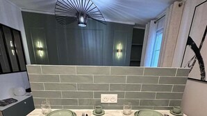 Una cocina moderna con encimera de mármol, dos taburetes de bar y un salpicadero con diseño geométrico.