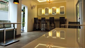 Un'area pranzo moderna con isola centrale, luci a sospensione e lampadario.