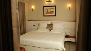 Una camera d'albergo con un letto grande, due comodini e un quadro appeso al muro.