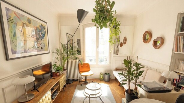 Een gezellige woonkamer met een houten salontafel, een moderne vloerlamp en een groot raam dat zorgt voor natuurlijk licht.