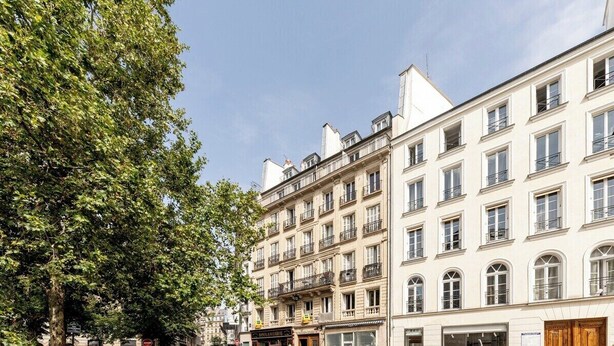 A row of multi-story buildings with uniform architecture, featuring balconies and large windows. - Spacious | in the Heart of the Marais | 4 people (Paris)