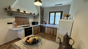 A kitchen with a central island, a microwave, a sink, and a refrigerator.