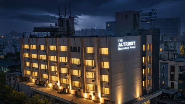 Un hotel de varios pisos con un letrero llamativo que dice 'The Altruist Business Hotel'.