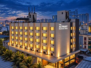A modern hotel building with multiple floors, large windows, and a flat roof. - The Altruist Wagholi Hotel (Pune)
