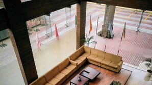 Un área de estar moderna con un sofá modular, dos mesas auxiliares y un mueble para televisión.