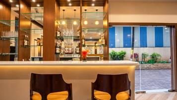 Una zona de bar con mostrador, taburetes y vistas al exterior.