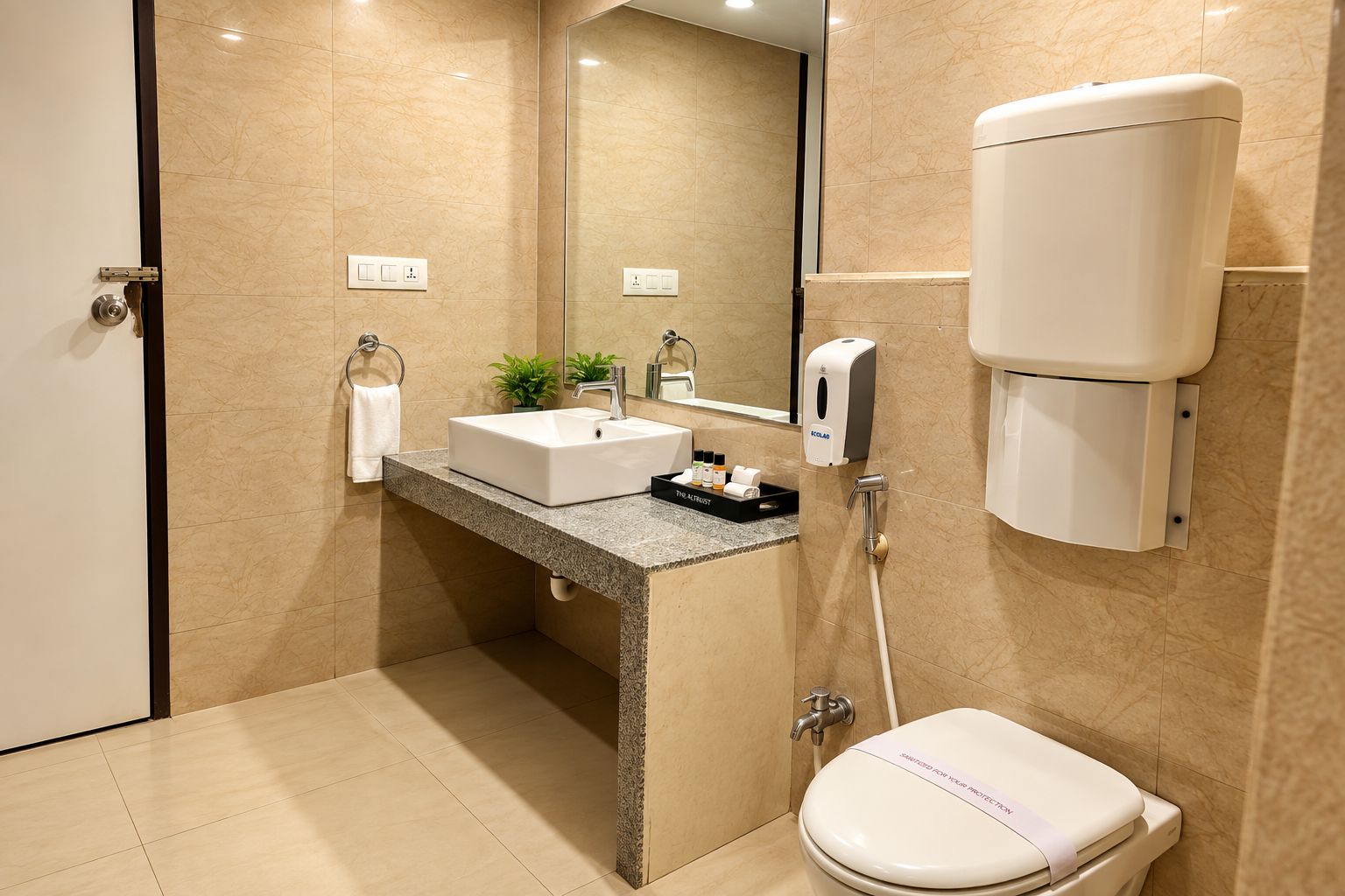 A modern bathroom with a marble sink, a handheld soap dispenser, and a toilet.