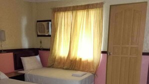 Une chambre d’hôtel avec deux lits, une fenêtre avec des rideaux, une porte et un sol carrelé.