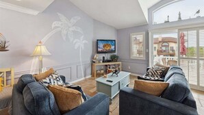 Ein Wohnzimmer mit einer Couch, einem Couchtisch und einem Fernseher.
