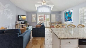 Ein geräumiger Wohnbereich mit Fernseher, Sofa und Essplatz.