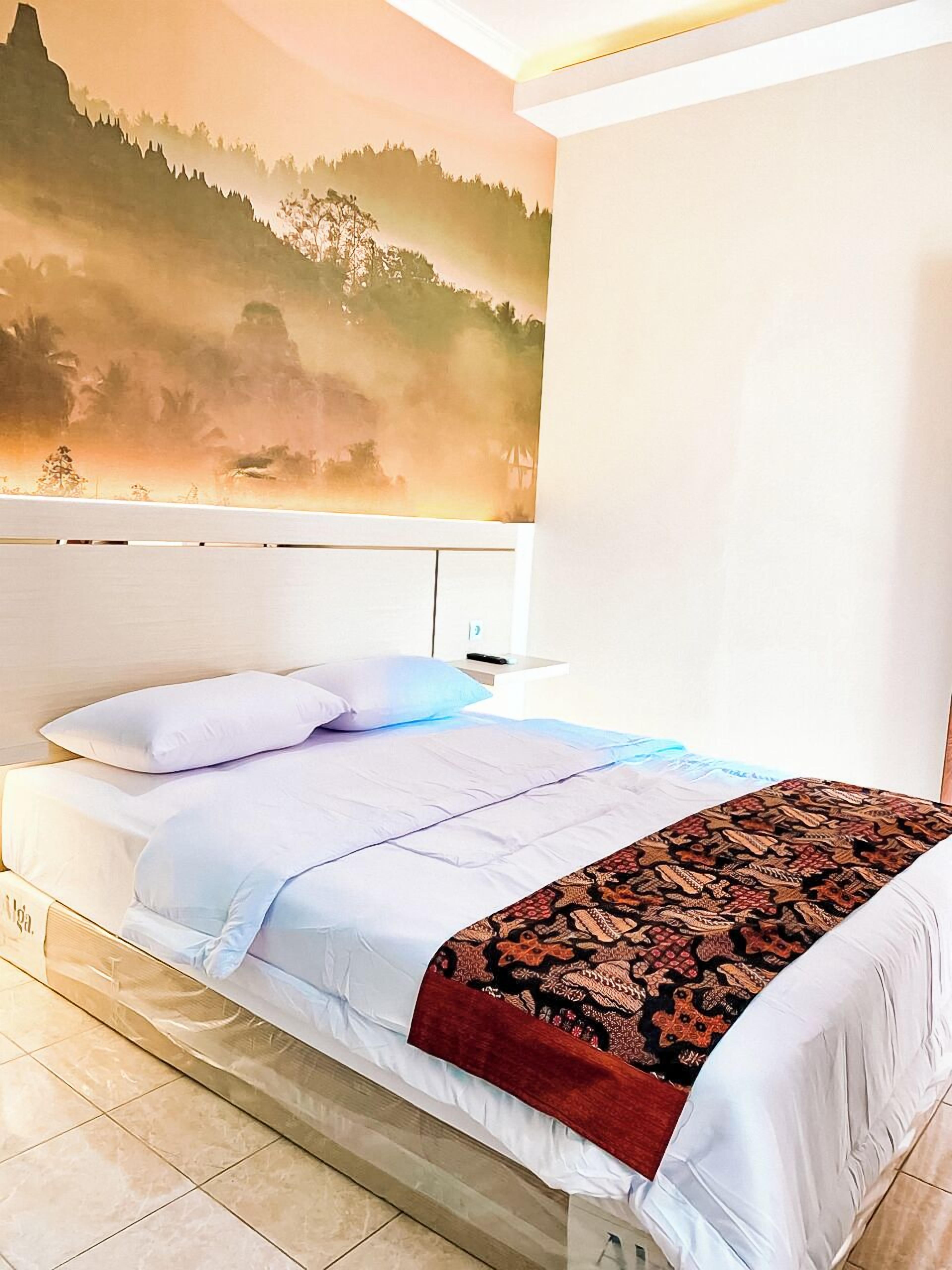 A bedroom with a bed, pillows, and a patterned blanket.