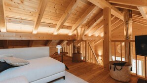 A wooden interior with a sofa, a lamp, a TV, and a fireplace.