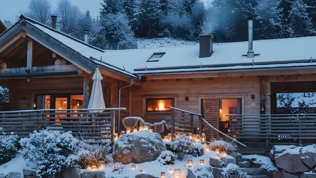 A wooden cabin with a fireplace, stone steps, and snow-covered landscape.