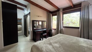 A bedroom with a bed, a dresser, a mirror, and a window with curtains. - San Lameer Villa 2802 (Southbroom)