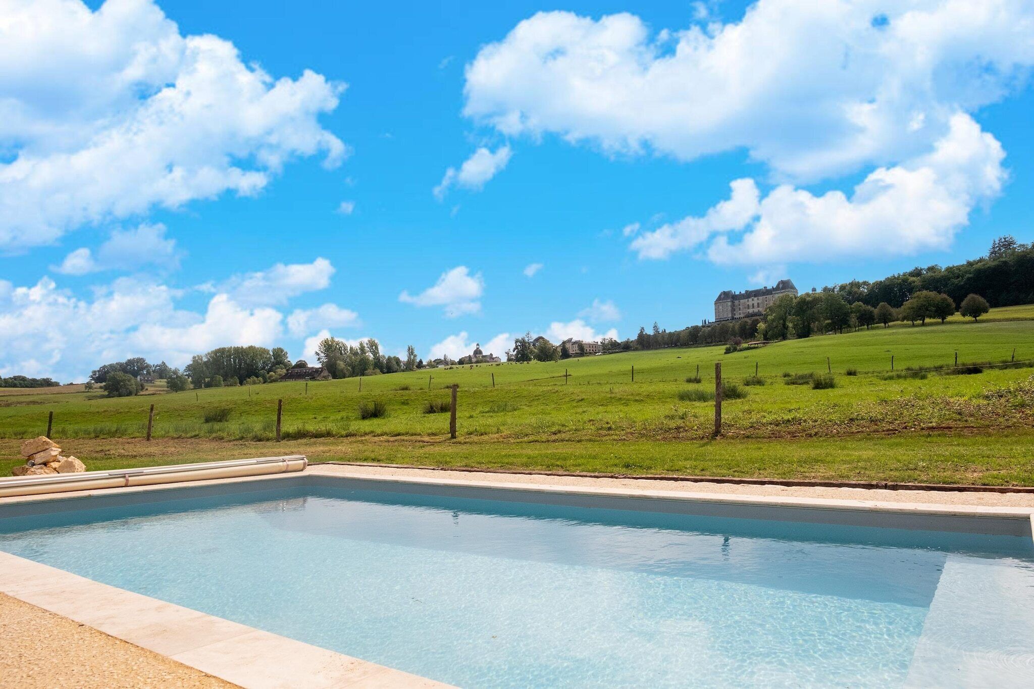 A swimming pool with a view of a large building in the background.