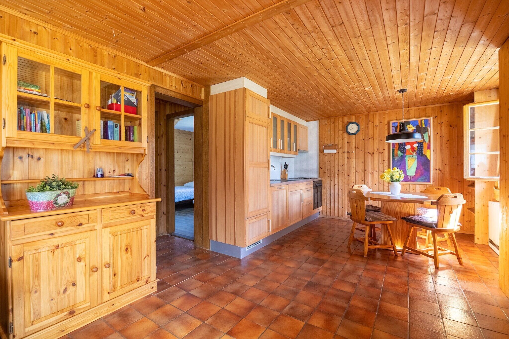 Un intérieur en bois comprenant un coin cuisine, une table à manger et des placards.