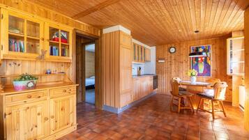Un intérieur en bois comprenant un coin cuisine, une table à manger et des placards.