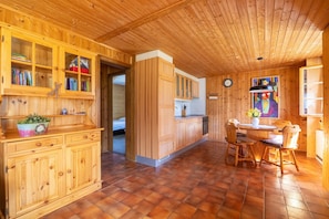 Un intérieur en bois comprenant un coin cuisine, une table à manger et des placards.