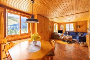 Un interno in legno con un tavolo da pranzo, un divano e una TV.